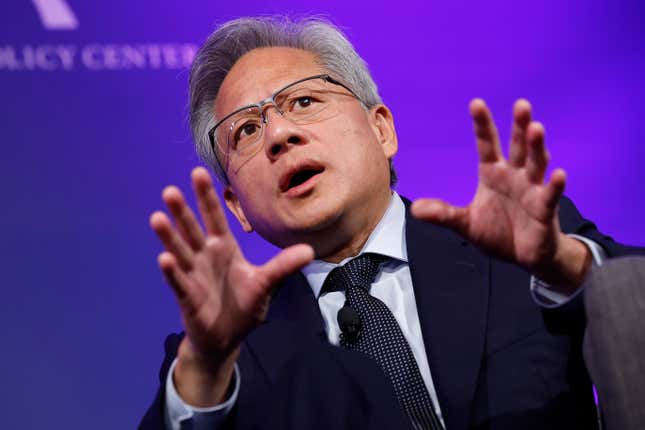 Jensen Huang speaks in front of a purple background with his hands raised and his head upwards.